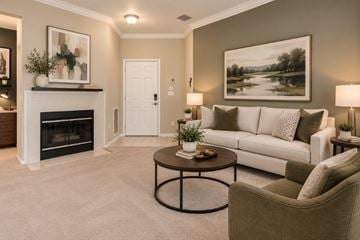 Sterling apartment for rent - A living room with a fireplace, a couch, a chair, and a painting on the wall.