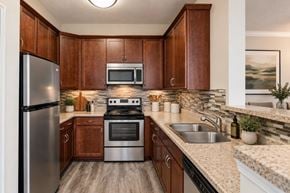 Sterling apartment for rent - A kitchen with wooden cabinets and a stainless steel refrigerator.