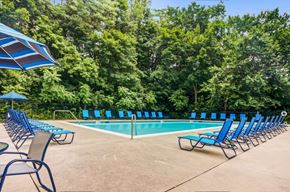 Conshohocken apartment for rent - a swimming pool with blue lounge chairs and umbrellas