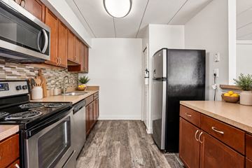 Devon apartment for rent - A kitchen with a black fridge and wooden cabinets.