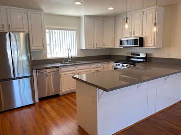 San Diego apartment for rent - a kitchen with stainless steel appliances and white cabinets