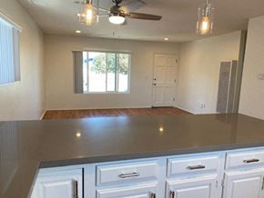 San Diego apartment for rent - an empty kitchen with white cabinets and a ceiling fan