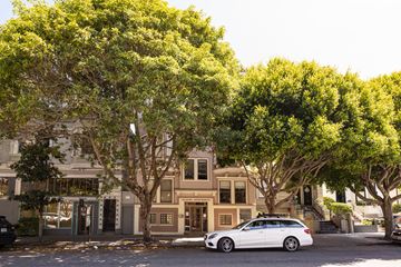 San Francisco apartment for rent - A white car is parked on the street in front of a building.