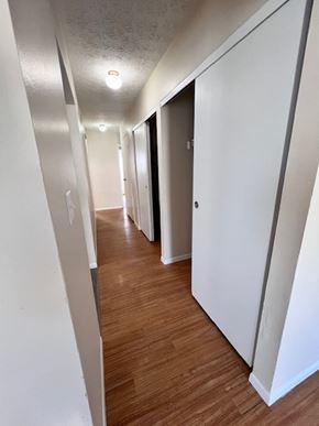Galloway apartment for rent - A long hallway with white walls and wood floors.