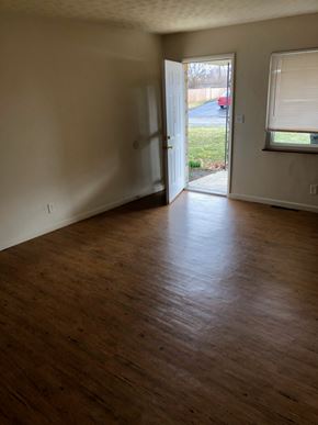 Columbus apartment for rent - A room with wooden floors and a doorway leading to a driveway.